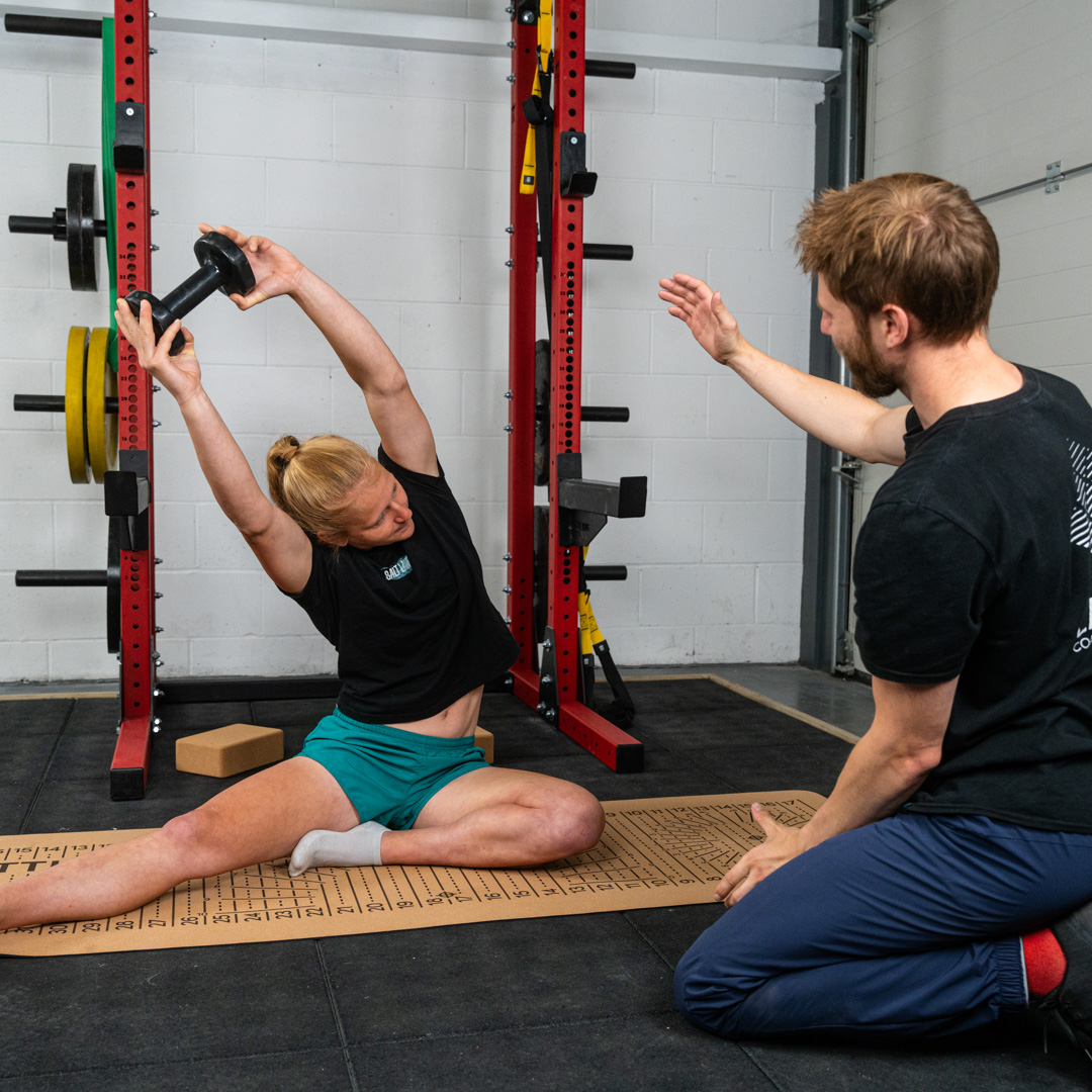 Lattice Coach Josh Hadley coaching coach Jen Wood for climbing stretching with a flex block on a flex mat