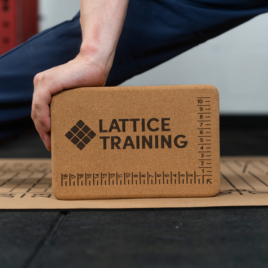 Lattice Coach Josh Hadley performing a box split stretch with a flex block on a flex mat