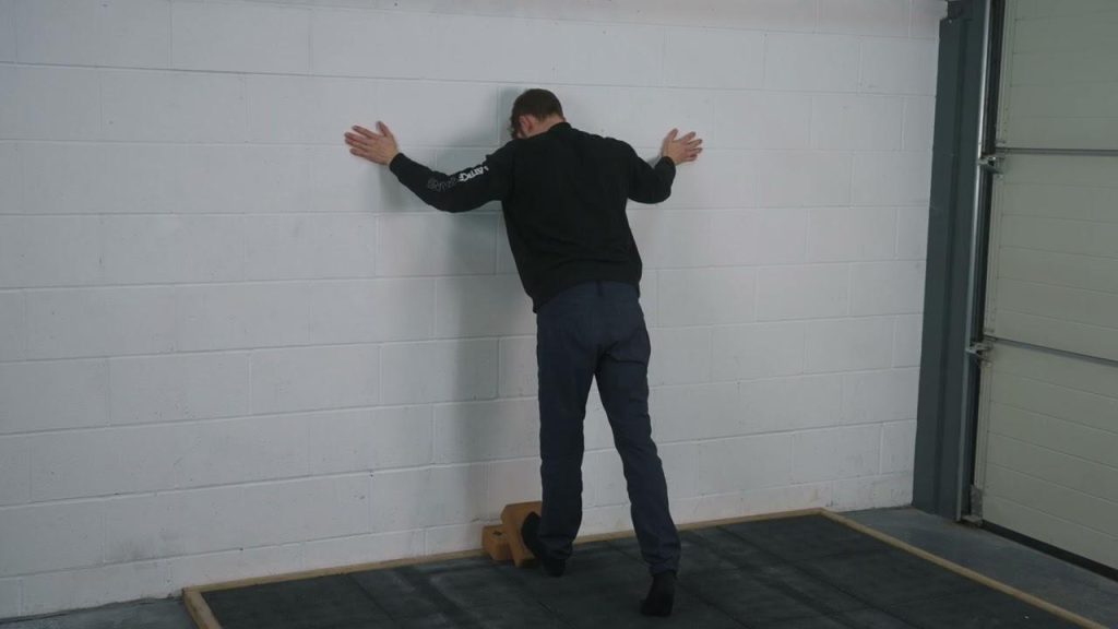 Lattice coach stretching calfs in a wall stretch. Good for climbers and runners. 