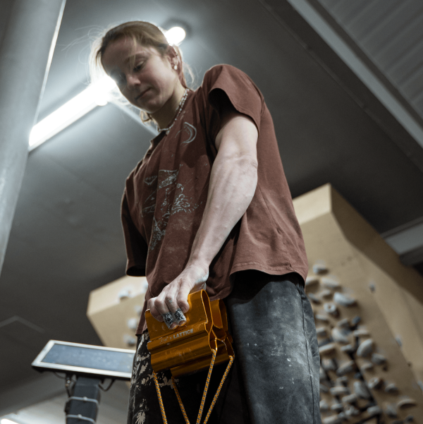 Erin McNeice using the Gold QUad Block in front of a bouldering wall