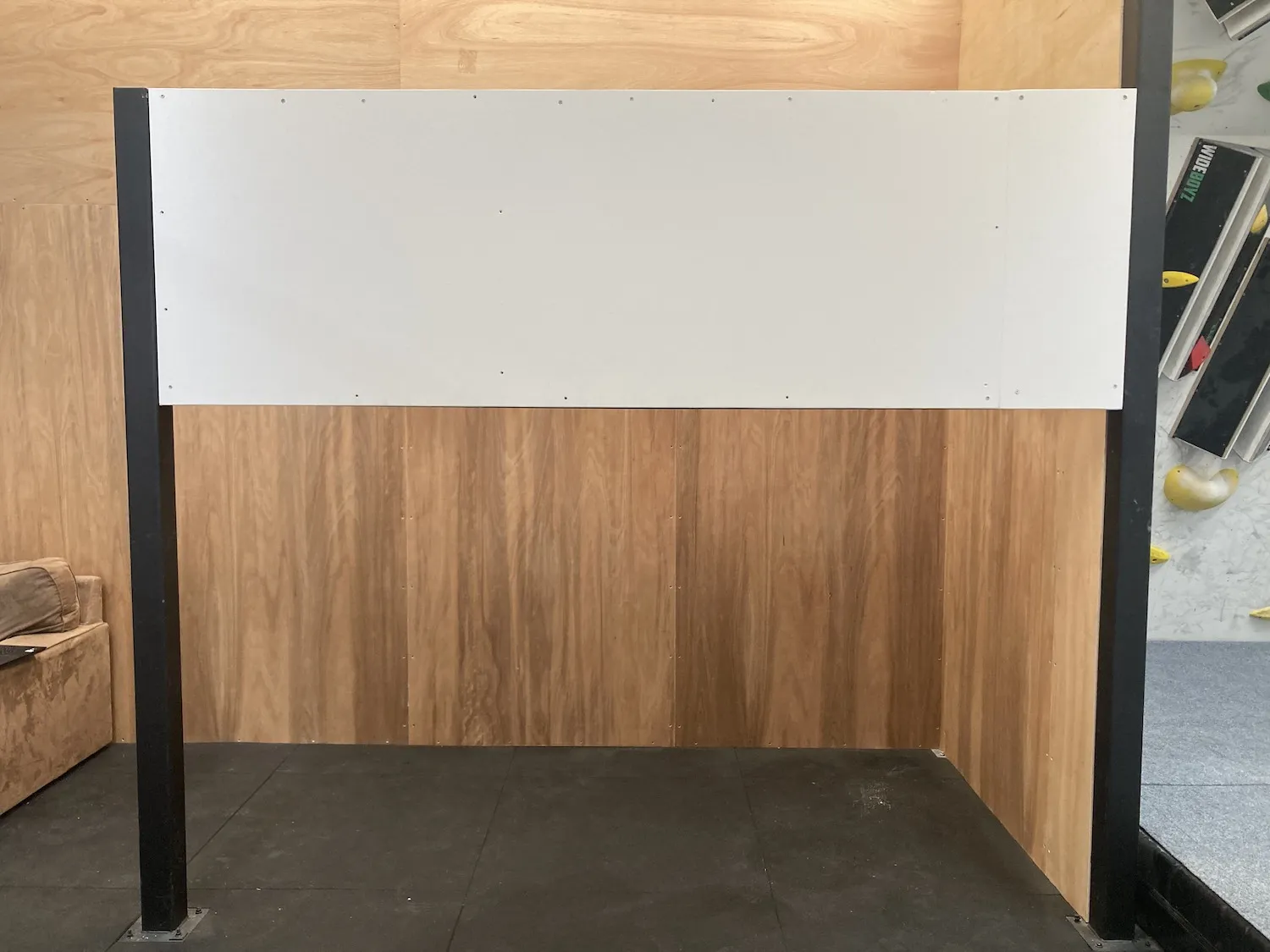 A flat melamine-faced board fixed across a freestanding timber frame, ready to take a wall mounted hangboard